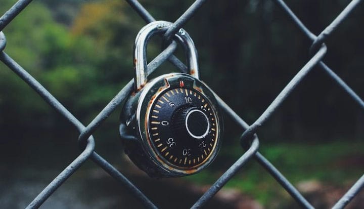 black and gray code padlock anchored on chain-link fence selective focus photo